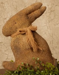 Pictured is a cute primitive fabric stuffed bunny. He has a guaze bow